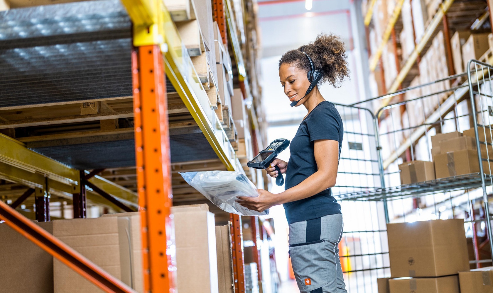 Warehouse worker scanning package on shelf